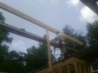 Carpenter setting a ridge beam over a new addition frame — Ice Dam Removal by Roofing Brothers in East Brookfield