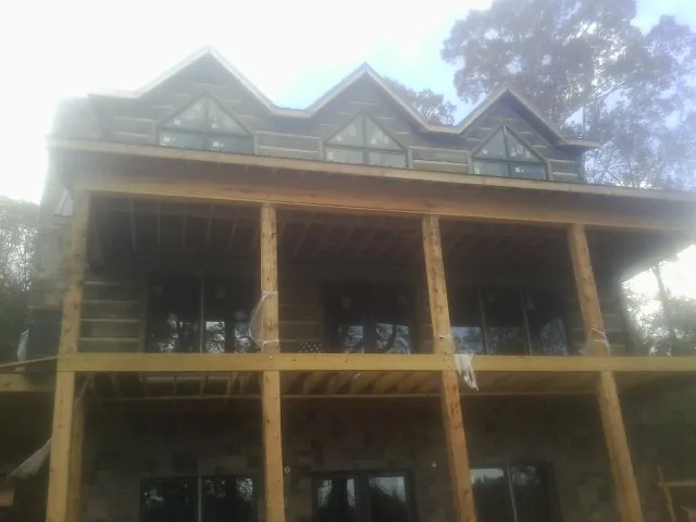 Dormers and porch framing on a large log home under construction — Roof Coating work by our crew in East Brookfield
