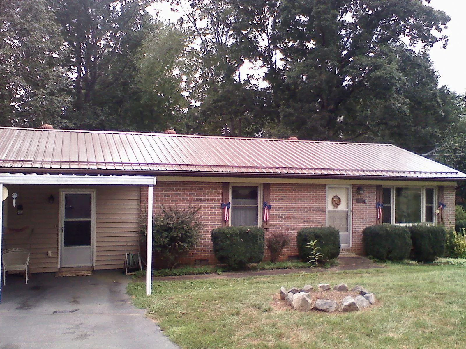 Bronze metal roof and carport on a brick ranch home — Roof Repair work by our crew in East Brookfield